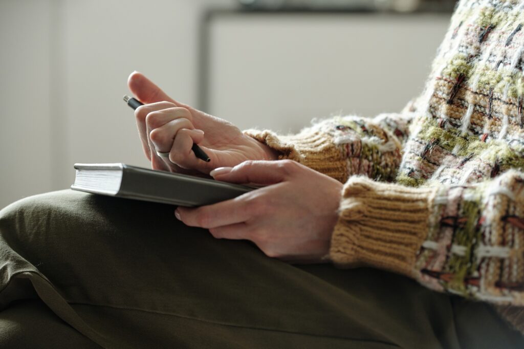 Young Woman Taking Notes during Therapy Session Indoors