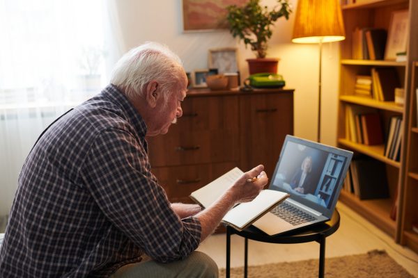 Old man having online consultation on laptop